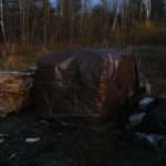 Covering the wood pile with a tarp.